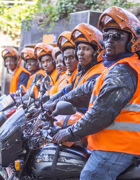 myMoto riders in orange vests and green helmets